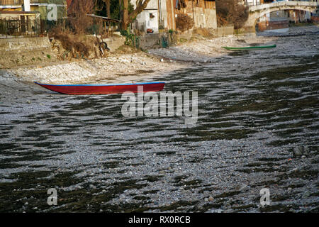 River drought, red boat without water due global warming. Stock Photo