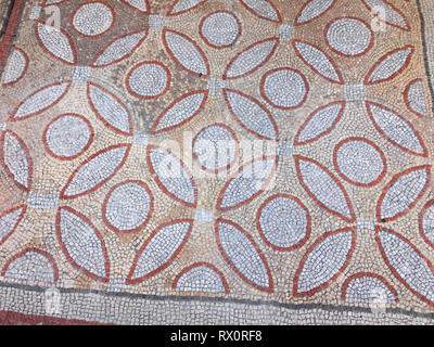 Fragment of an ancient floor mosaic. Colorful small tiles, unusual geometric ornament, floral and regular forms. Crimea Hersones Stock Photo
