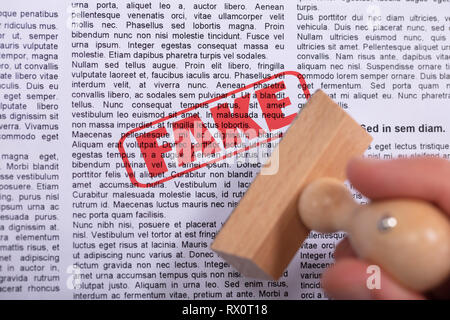 Close-up Of A Person Stamping Fake Rubber Stamp On Paper Stock Photo