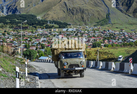 Kazbegi, Georgia - Sep 24, 2018. A truck carrying grass on mountain road at sunny day in Kazbegi, Georgia. Stock Photo