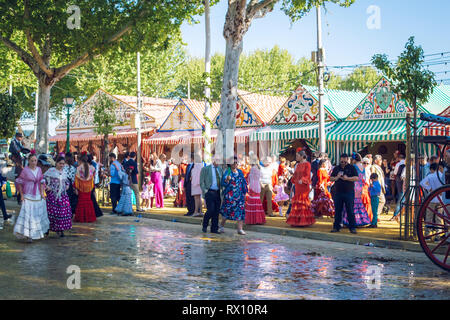 People dressed in traditional costumes enjoy April Fair. Seville Fair (Feria de Sevilla). Stock Photo