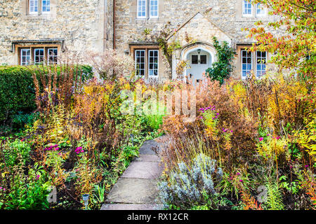 The autumnal front garden of a stone cottage in the Cotswolds, England. Stock Photo