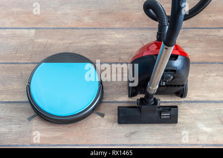 Old versus new and technology evolution concepts. Robot and regular vacuum cleaners side by side. Stock Photo