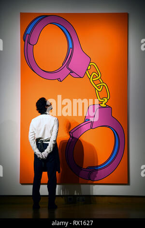 Embargoed to 2300 Friday March 8 An art handler looks at Handcuffs by Michael Craig-Martin, during a photo call for The George Michael Collection art sale at Christie's, London. Stock Photo