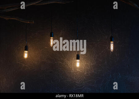 Decorative antique edison style light bulbs against brick wall background Stock Photo