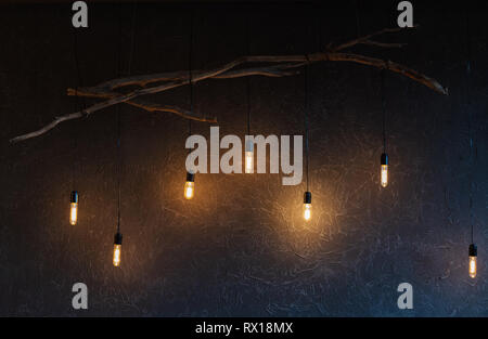 Decorative antique edison style light bulbs against brick wall background Stock Photo
