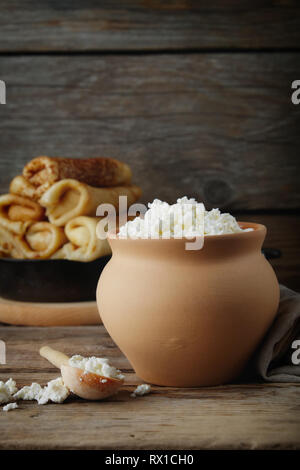 Cottage cheese in  clay pot. and pancakes. Copy space for text. Stock Photo