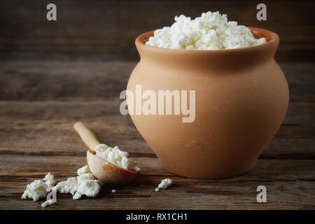 Cottage cheese in rustic vintage clay pot. Stock Photo