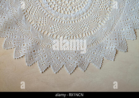 Upper edging with openwork white napkin on light plywood knitted from thin cotton threads Stock Photo