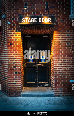 Full height doorway and Stage Door sign illuminated with spotlights at the Stage Door of Cambridge Theatre in Shelton Street, Covent Garden, London Stock Photo