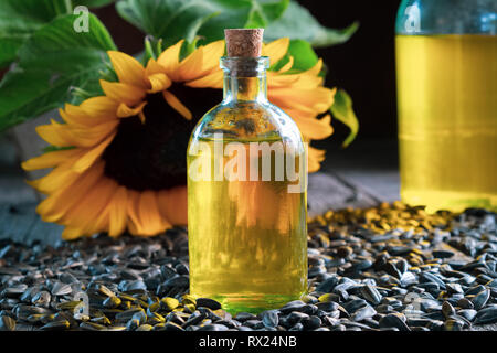 Bottle of fresh sunflower oil, seeds and  sunflower on background. Stock Photo