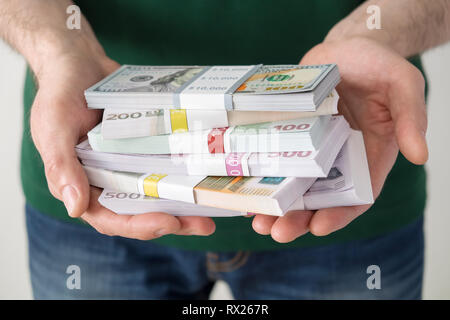 Man holding a stacks of euros and dollars in his hands. Stock Photo