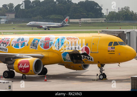 AirAsia Airbus A320-216 airliner in bright yellow livery advertising Expedia travel company at Changi International Airport. Stock Photo