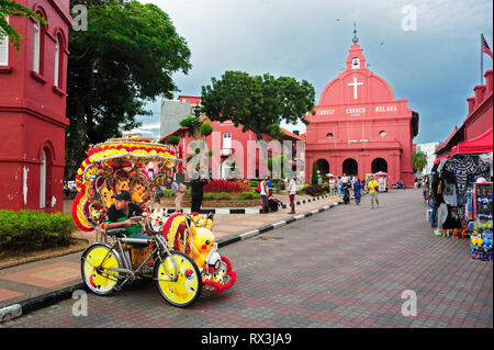 Bicycle rickshaw driver on the street in Old Town, Melaka, Malaysia Stock Photo