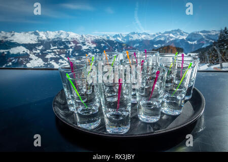 many schnapps glasses in front of a blue sky in a skiing area, drink alcohol on the slopes Stock Photo