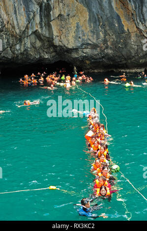 people on a line swimming in to Morakot Cave, Emerald Cave, Koh Muk, Trang Province, Thailand Stock Photo