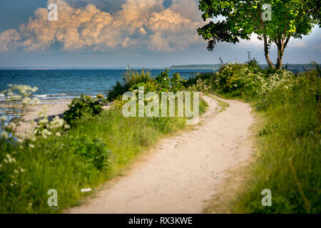 a narrow path leads to the beach from the sea Stock Photo