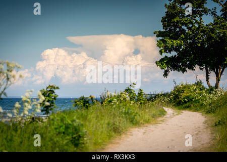 a narrow path leads to the beach from the sea Stock Photo