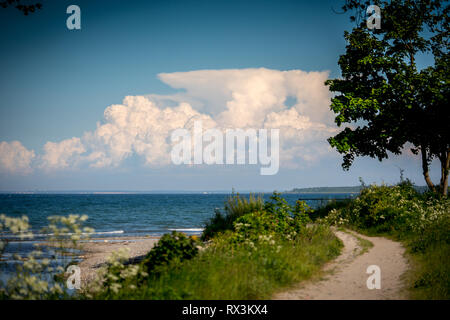 a narrow path leads to the beach from the sea Stock Photo