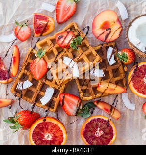 Waffles with strawberries, coconut, plum and orange with chocolate Stock Photo