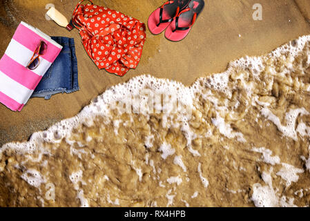 Summer Beach accessories laying on sand in empty sea beach Stock Photo