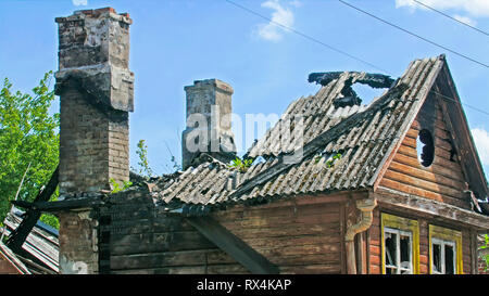 A wrecked old burnt house. No more roof left and some ashes are still there Stock Photo