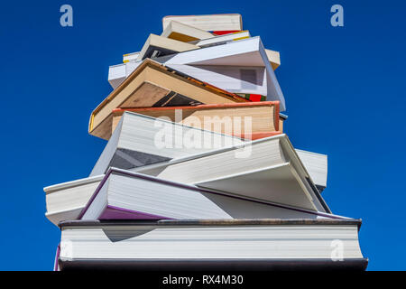 Stack of books of descending magnitude against a beautiful blue sky on a sunny day Stock Photo