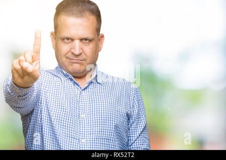 Middle age arab business man over isolated background Pointing with finger up and angry expression Stock Photo