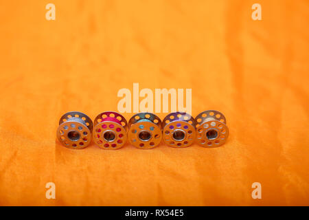 Portrait of many bobbin . Isolated on the yellow background. Stock Photo