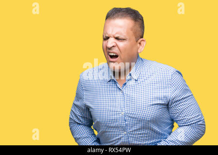 Middle age arab business man over isolated background with hand on stomach because indigestion, painful illness feeling unwell. Ache concept. Stock Photo