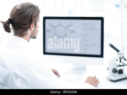 Young man working in a medical lab using a computer Stock Photo