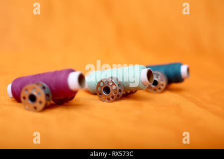 Picture of thread and bobbins. Isolated on the yellow background. Stock Photo