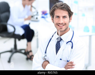 Handsome male doctor smiling with arms crossed on chest portrait Stock Photo