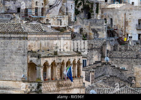 MATERA, ITALY - AUGUST 27, 2018: Summer day high angle close-up street view of ancient stone carved terrace and flags of Matera, Italy and the Europea Stock Photo