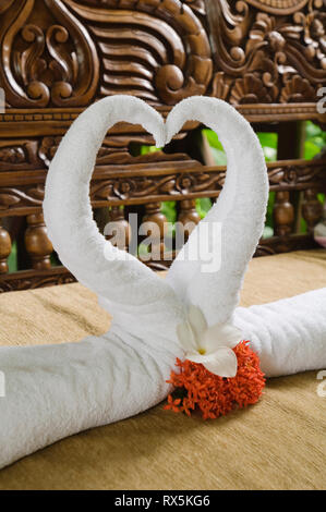 Towels in heart shape with flowers Stock Photo
