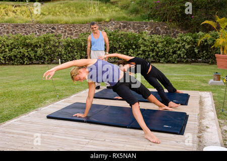 Man teaching women yoga in park Stock Photo