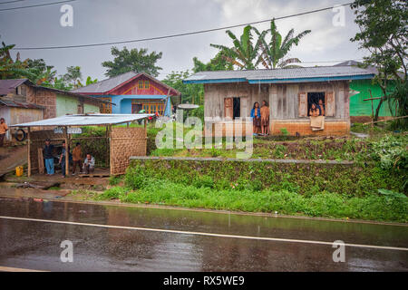 Asian kids waiting for the rain to stop. Flores is one of the Lesser Sunda Islands, a group of islands in the eastern half of Indonesia. Stock Photo