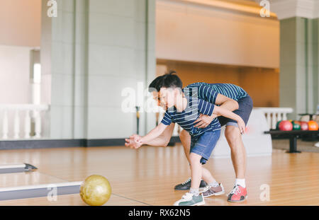 Asian family having fun at bowling club Stock Photo