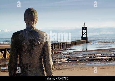 An iron man watching the tower on Crosby beach Stock Photo