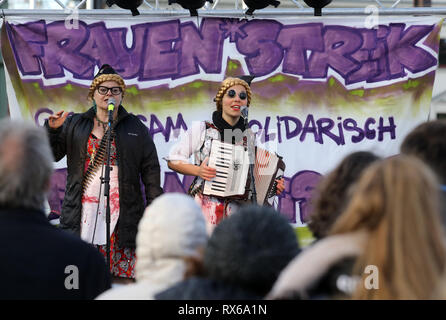 Rostock, Germany. 08th Mar, 2019. During the women's strike on the Neuer Markt the 'anti-capitalist yodelling duo Esels Alptraum' sings, on the banner at the stage there is 'FRAUEN*STREIK'. Around 300 women (and men) take part in the campaign on International Women's Day. Credit: Bernd Wüstneck/dpa/ZB/dpa/Alamy Live News Stock Photo