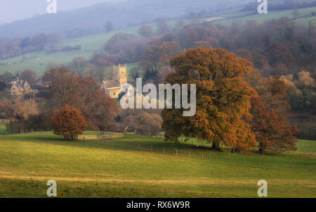 Cotswolds St. Eadburgha's Church in Autumn nestled in early morning sunlight Stock Photo