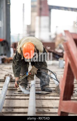 factory workers at Koksokhim, welders are engaged in the construction and installation of metal structures on high ground and in special working condi Stock Photo