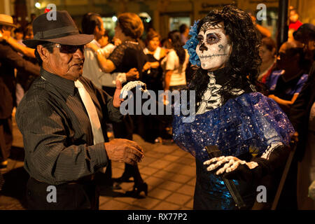 Some of the attendees come disguised as the dead to the dance held in the city square on the occasion of the celebration of the Day of the Dead. Stock Photo