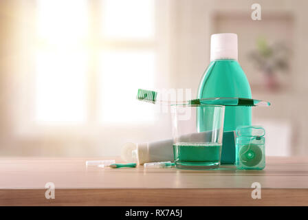 Equipment for oral hygiene on wood table in bathroom with window in the background. Horizontal composition. Front view. Stock Photo