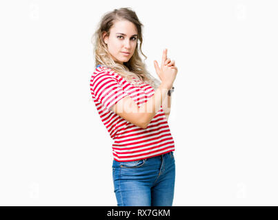 Beautiful young blonde woman over isolated background Holding symbolic gun with hand gesture, playing killing shooting weapons, angry face Stock Photo