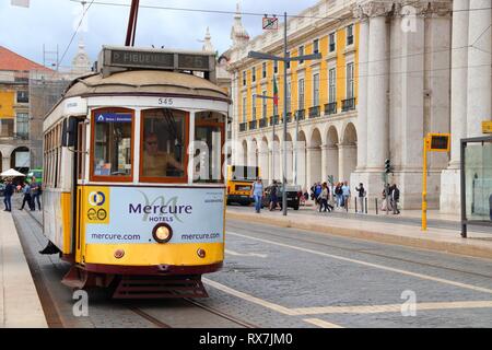 LISBON, PORTUGAL - JUNE 4, 2018: People ride the yellow tram in Praca Comercio square in Lisbon, Portugal. Lisbon's tram network dates back to 1873 an Stock Photo