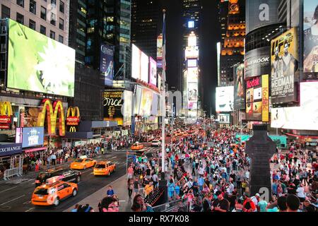 NEW YORK, USA - JULY 1, 2013: People visit Times Square in New York. The square at junction of Broadway and 7th Avenue has some 39 million visitors an Stock Photo