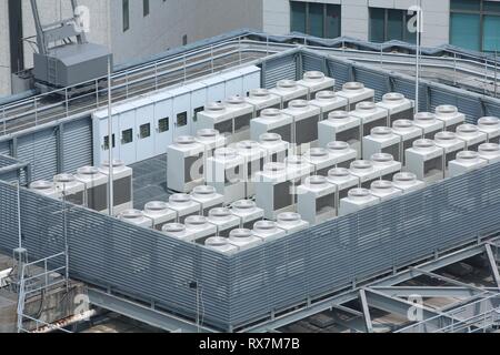 Exhaust vents of industrial air conditioning and ventilation units. Skyscraper roof top in Kobe, Japan. Stock Photo