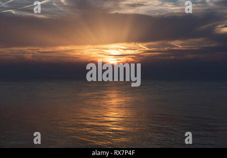 Sunset over sea with clouds and sunburst, from Herne Bay Kent UK Stock Photo
