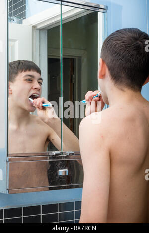 Teenage caucasian boy cleaning his teeth in the morning Stock Photo